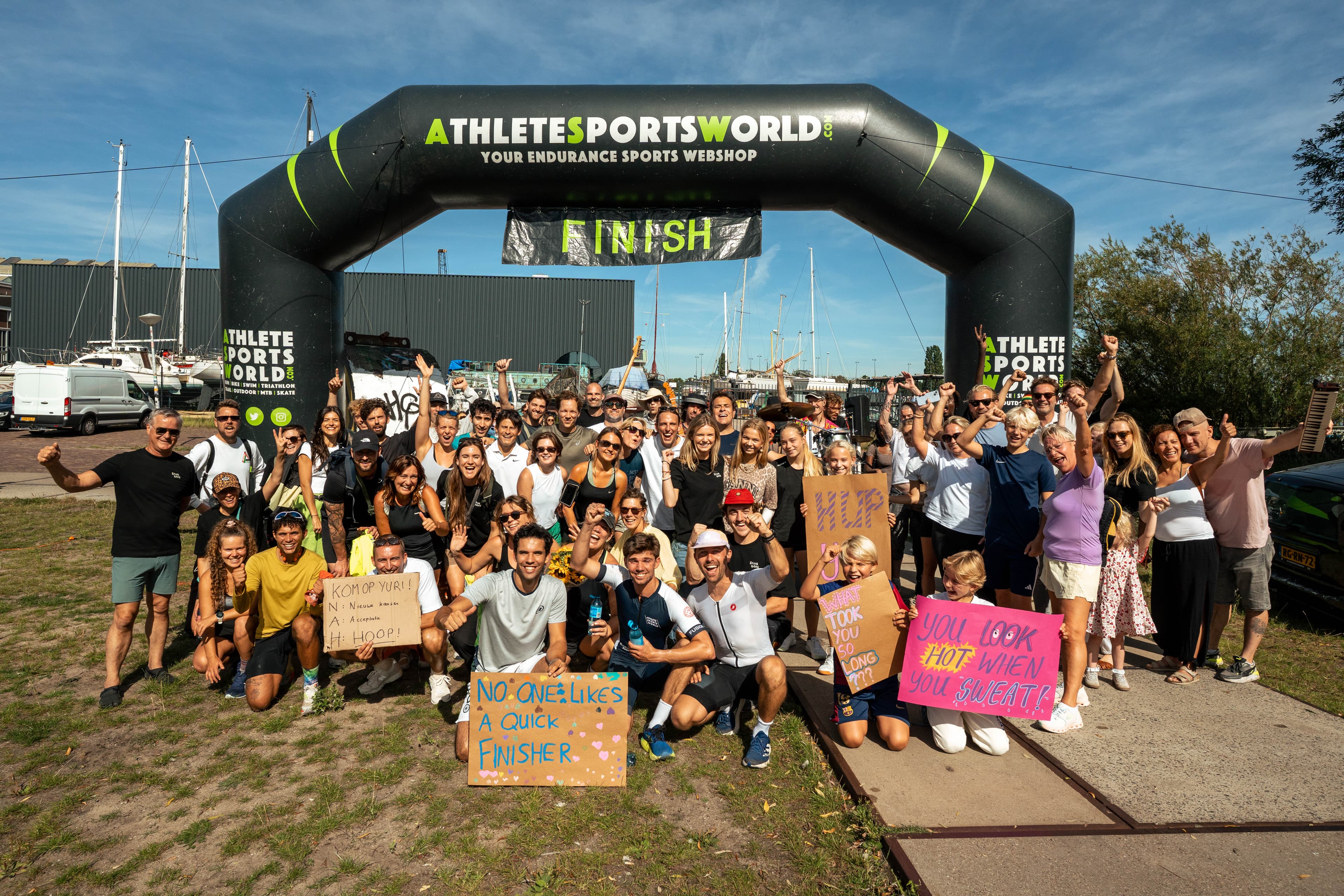 Het team viert de finish onder de finishboog met HOOP-borden